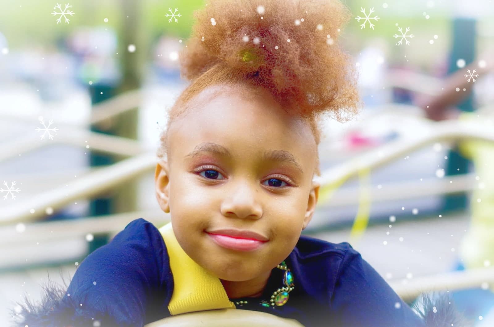 A smiling little girl in Winter Wonderland, snow falling around her