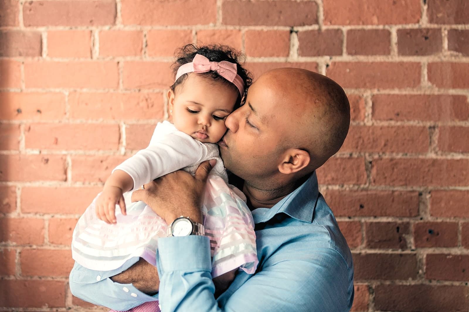 A father holding his young son outside, in Natural Light