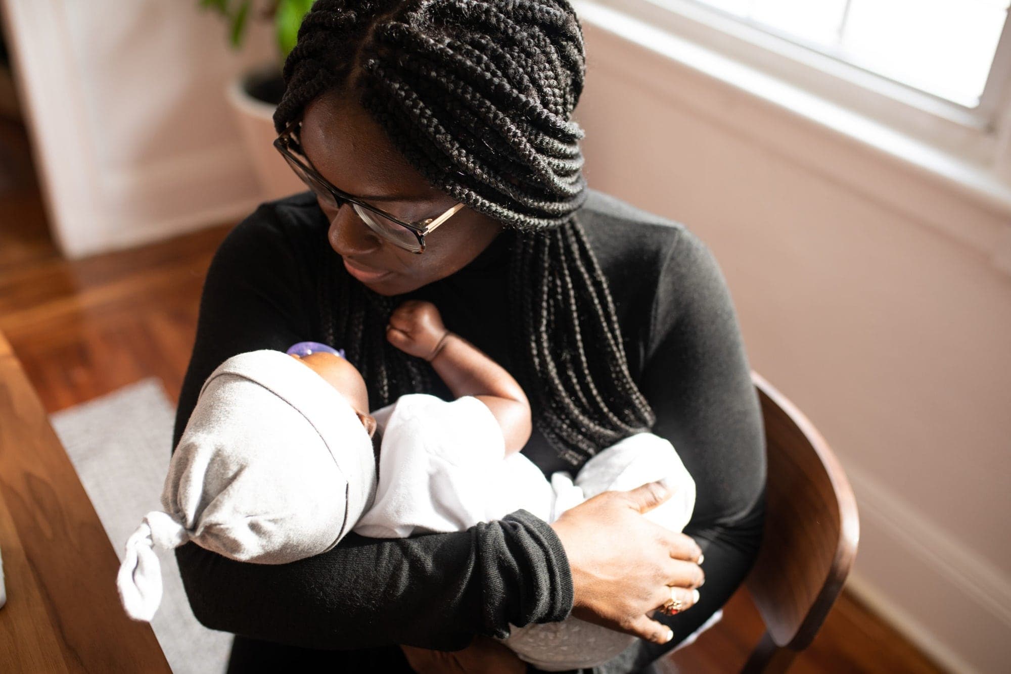 A mother gazing down at the newborn in her arms